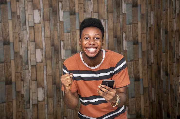 Man celebrating after recharging airtime on his phone